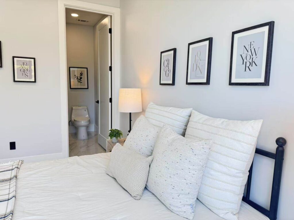 bed-facing-bathroom-door A bedroom layout where the bed directly faces an open bathroom door with a visible toilet.