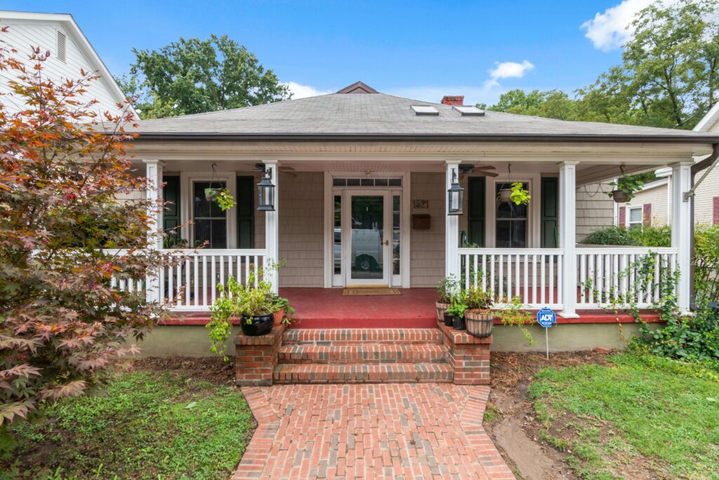A welcoming front porch with a central door, plants, and white railing—ideal feng shui entry.