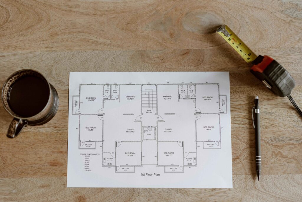 bathroom inthe center House floor plan showing bathroom located in the center of the home, surrounded by measuring tape, coffee cup, and pen on a wooden table