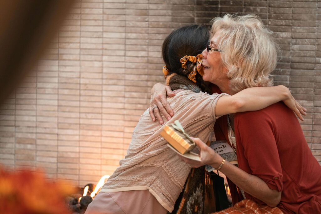 Two women embracing with joy and gratitude, symbolizing the highest Feng Shui intention during autumn holidays
