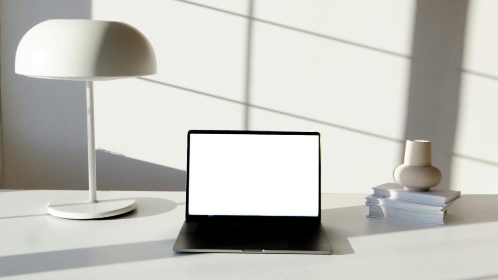 Minimal desk showing Green Dragon higher than White Tiger: taller lamp on the left and lower items on the right