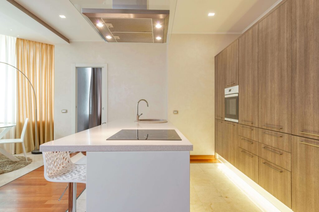 open-kitchen-island-fengshui Modern open kitchen with a large island, warm lighting, and wood cabinetry designed to balance energy flow