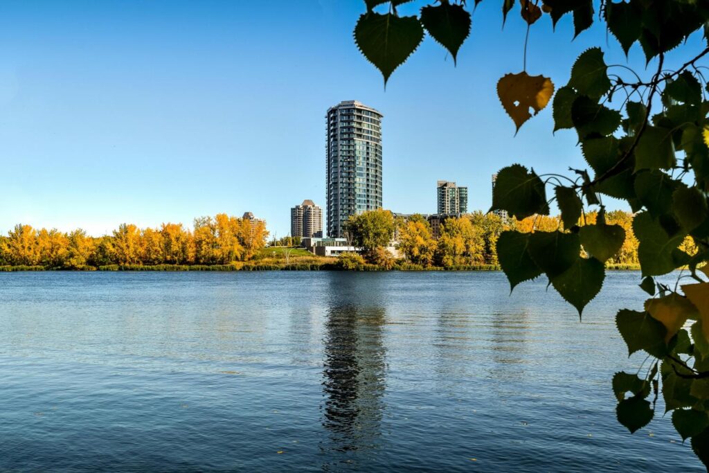 “High-rise condos near water and greenery, symbolizing good Feng Shui factors to consider when selecting a condo.”