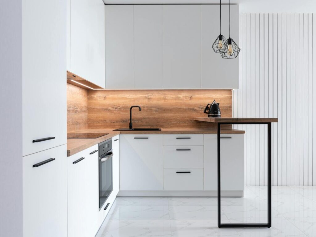 Modern minimalist kitchen with stove and sink separated, clean white cabinets, and bright lighting, representing balanced feng shui design.