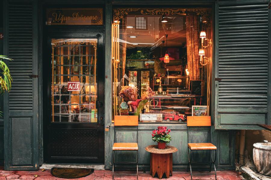 Charming retail storefront with clear signage, welcoming decor, and plants at the entrance