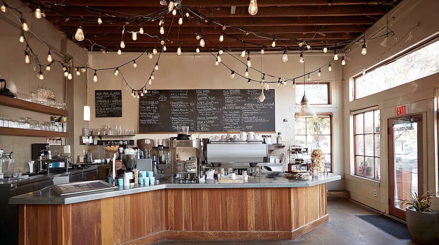 Cozy coffee shop interior with wooden counter, string lights, and welcoming atmosphere, symbolizing Feng Shui for small businesses